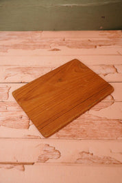 A vintage wooden chopping board for use in the kitchen.